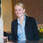 A young employee wearing a suit, talking to her manager about moving up in her career.