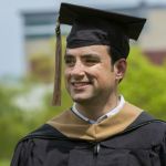 Ryan Farage smiling in his graduation attire after completing his Master of Science in Management, Strategy and Leadership.