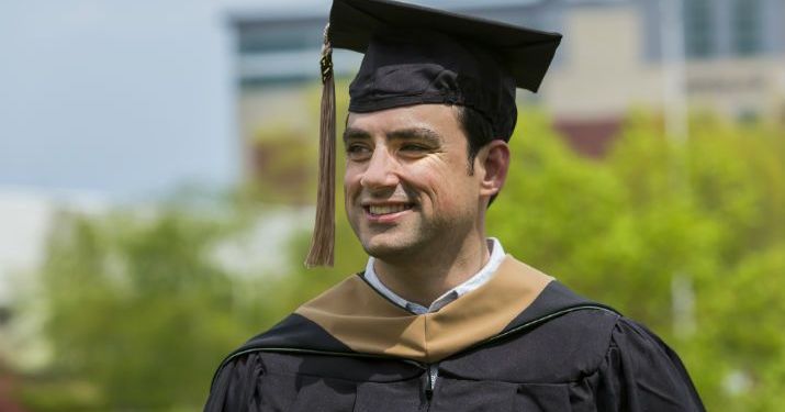 Ryan Farage smiling in his graduation attire after completing his Master of Science in Management, Strategy and Leadership.