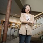 Supply chain grad Xuesi Li standing in an office smiling at the camera.
