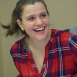 Ana Cifuentes Gonzalez, supply chain management grad, sitting in a chair, leaning forward and smiling.