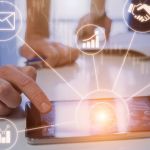 Close up of someone using a tablet with holographic images depicting mobile business analytics.