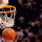 Close up shot of a basketball that's just gone through the net of the basketball hoop, with the net still in motion.