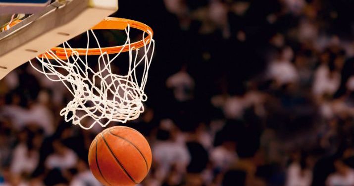 Close up shot of a basketball that's just gone through the net of the basketball hoop, with the net still in motion.