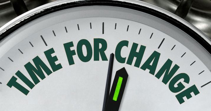View of the top half of a clock with the minute and hour hands pointing to the words "time for change" instead of numbers.
