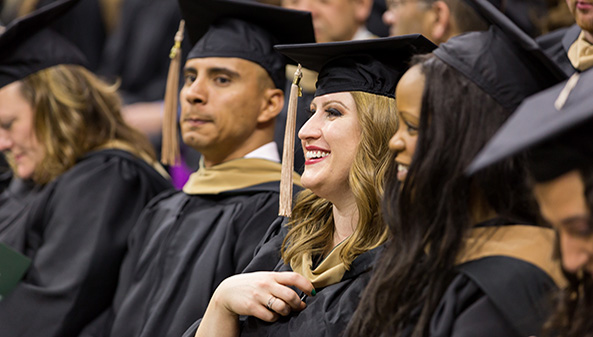 Crowd of MSU graduates at their graduation ceremony, wearing caps and gowns.