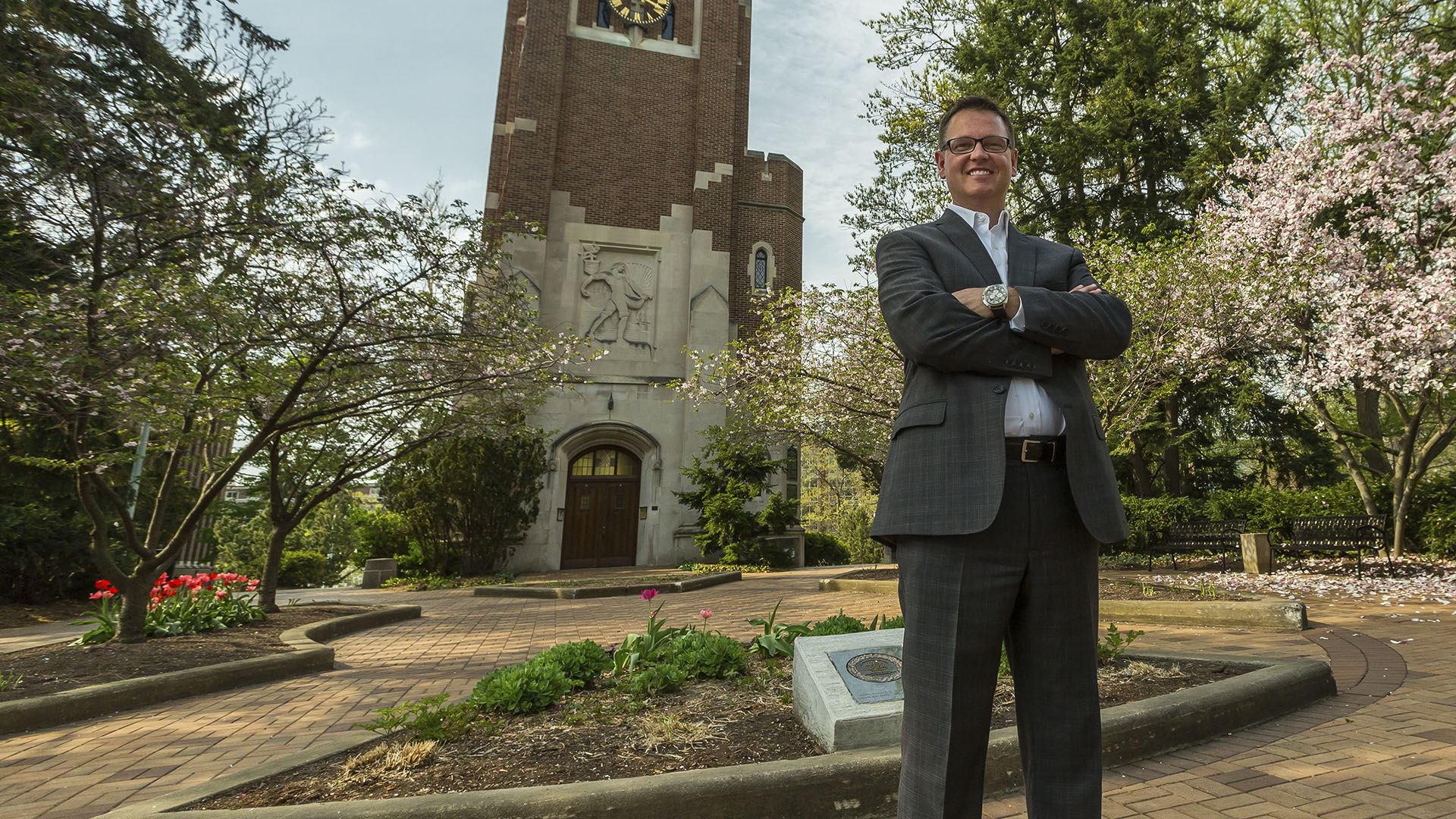 Jeff Day, MS in Management, Strategy and Leadership grad, standing in a business suit on MSU's campus.