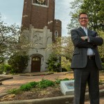 Jeff Day, MS in Management, Strategy and Leadership grad, standing in a business suit on MSU's campus.