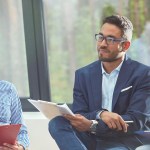 Office employees sitting together in a meeting, listening intently to someone speaking.