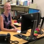 Lisa Karell, who earned her professional certificate in change management, sitting at her desk and smiling.