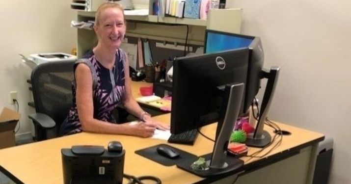 Lisa Karell, who earned her professional certificate in change management, sitting at her desk and smiling.