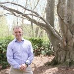 Matt McKenna, MS in Management, Strategy and Leadership Grad, smiling in front of a large tree on the MSU campus.
