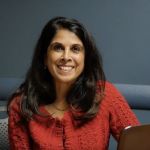Roz Jaffer, Assistant Professor of Management at the Broad College of Business, sitting at a desk smiling.