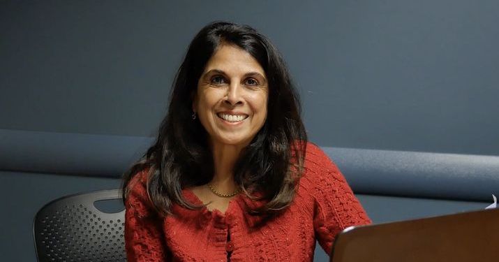 Roz Jaffer, Assistant Professor of Management at the Broad College of Business, sitting at a desk smiling.
