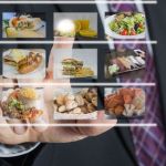 Man in a business suit ordering food off of a holographic menu.