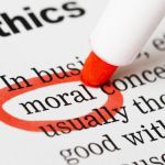 A sheet of paper that says "Ethics" at the top with some text underneath and a red circle being drawn with a marker around the word"moral".