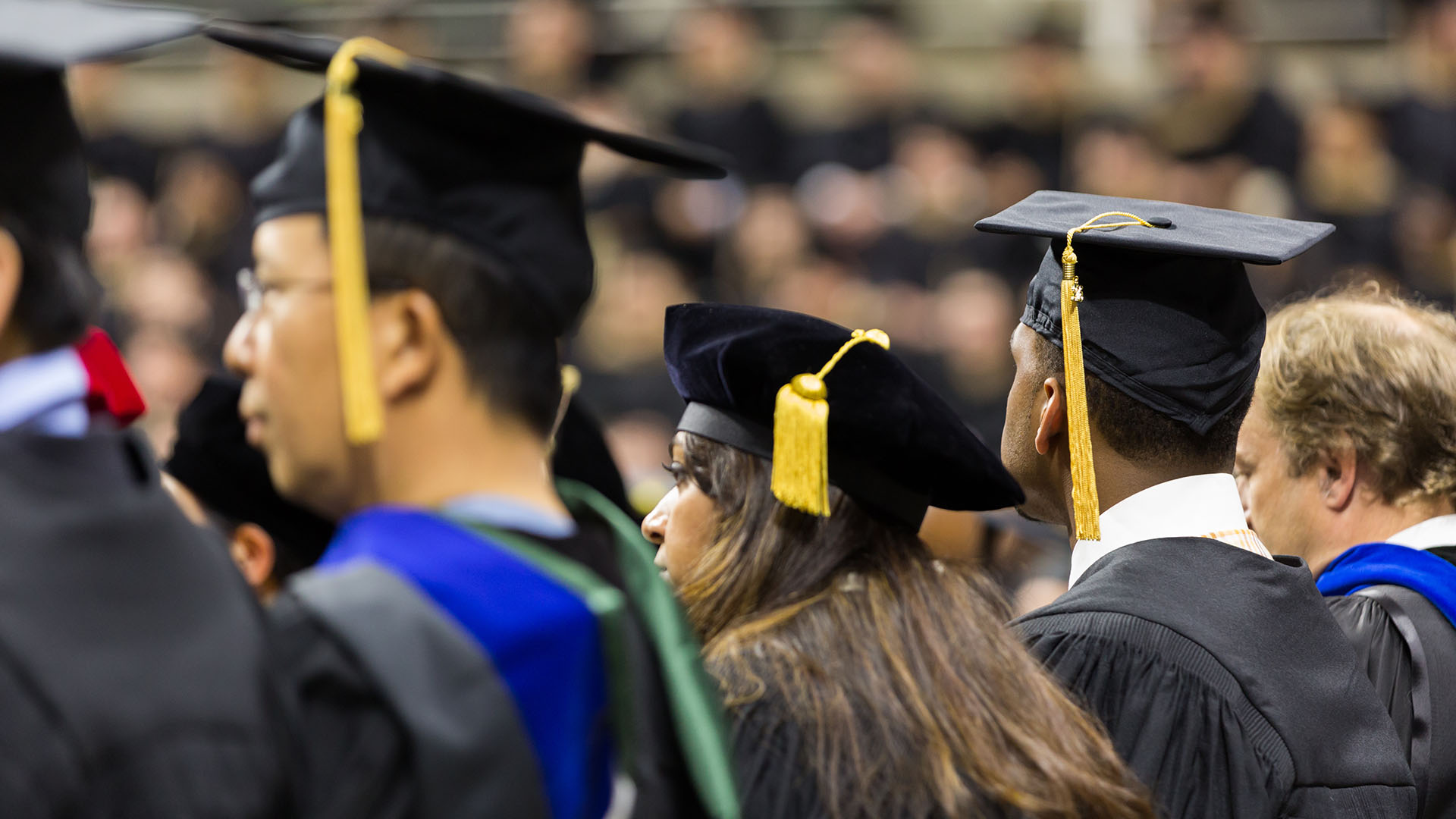 Close up of three graduates at an MSU graduation ceremony.