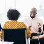 Team leader conducting a collaboration meeting in an office.